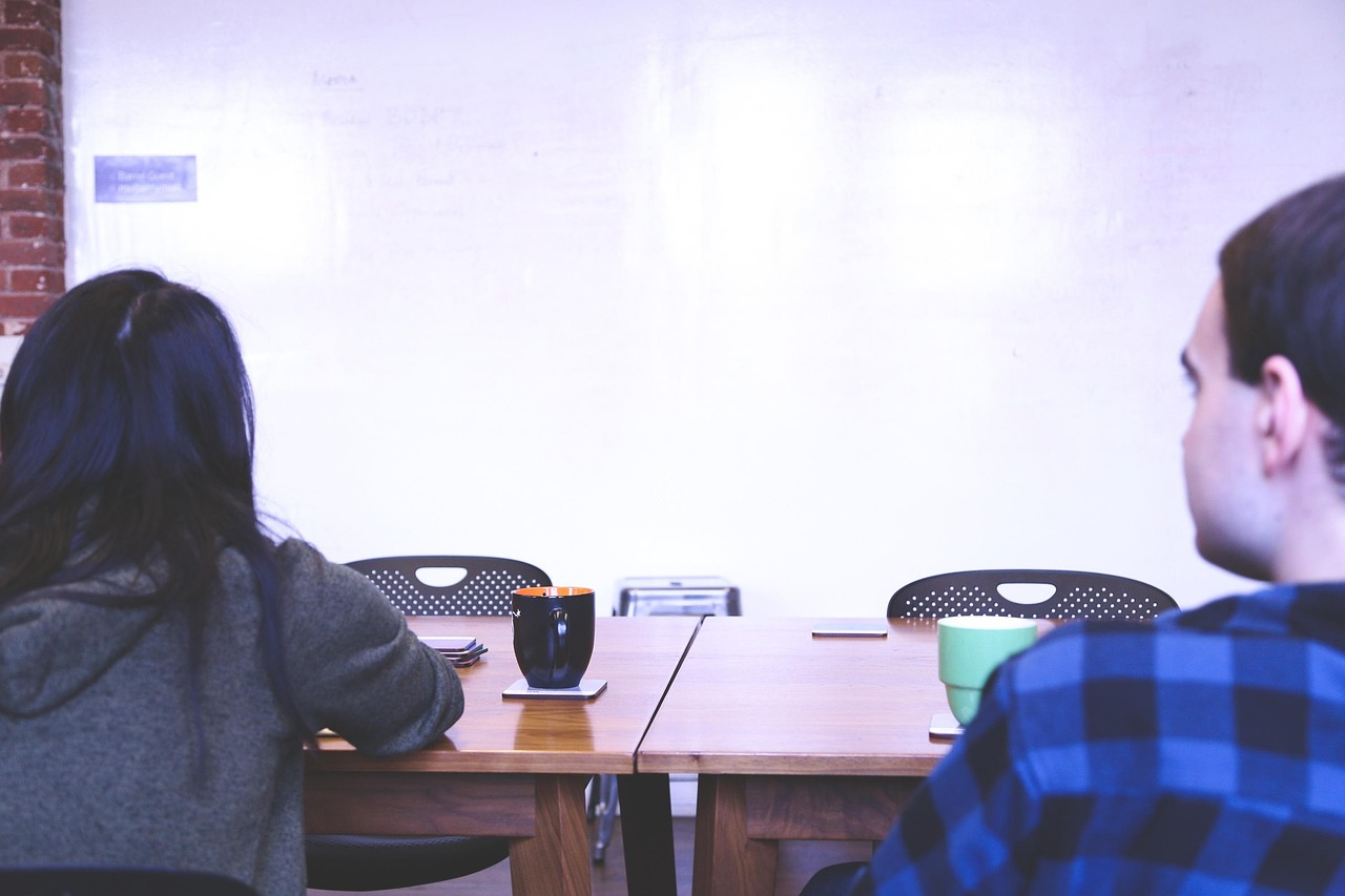 A business team discussing strategy around a whiteboard