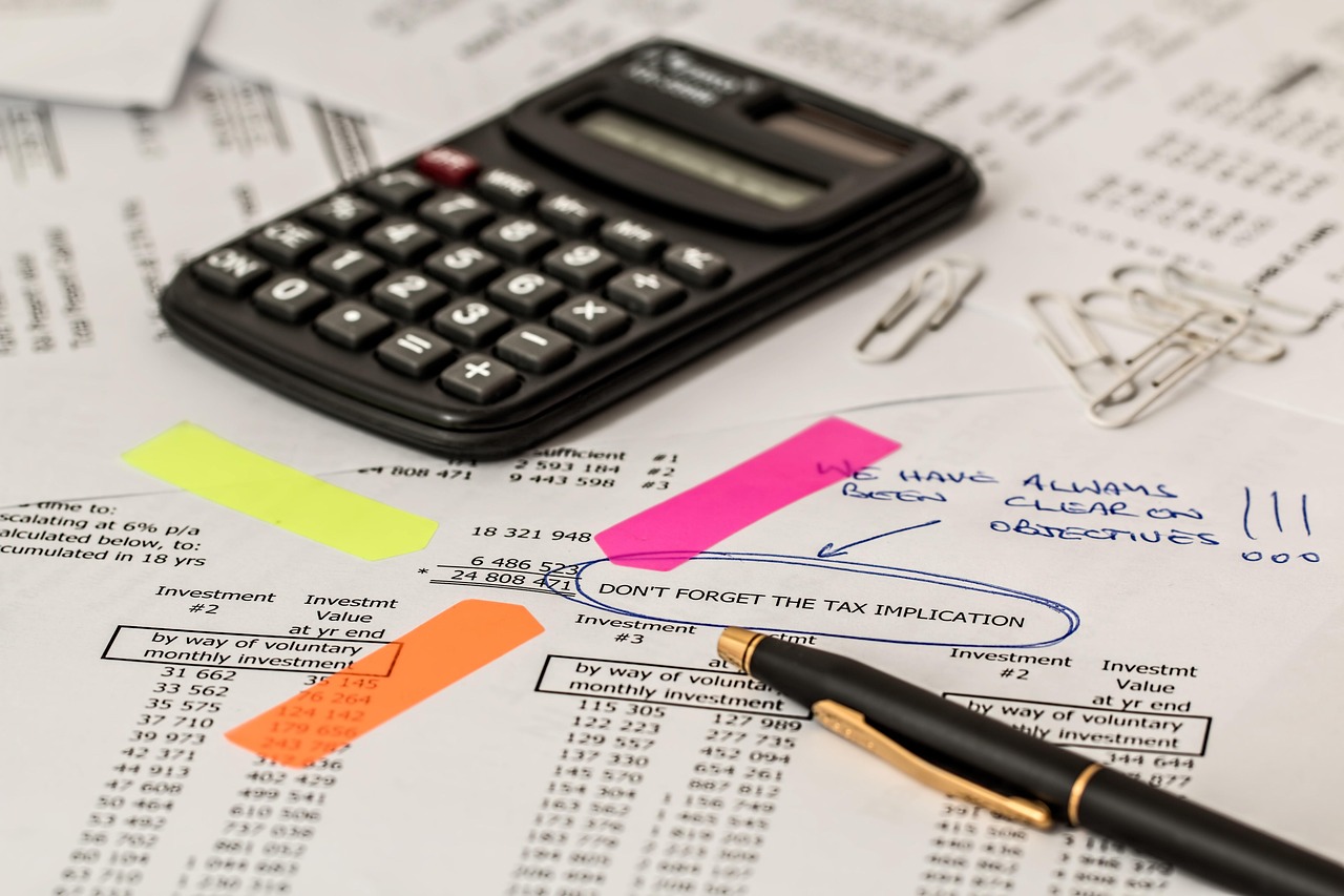 A calculator and pen resting on financial documents