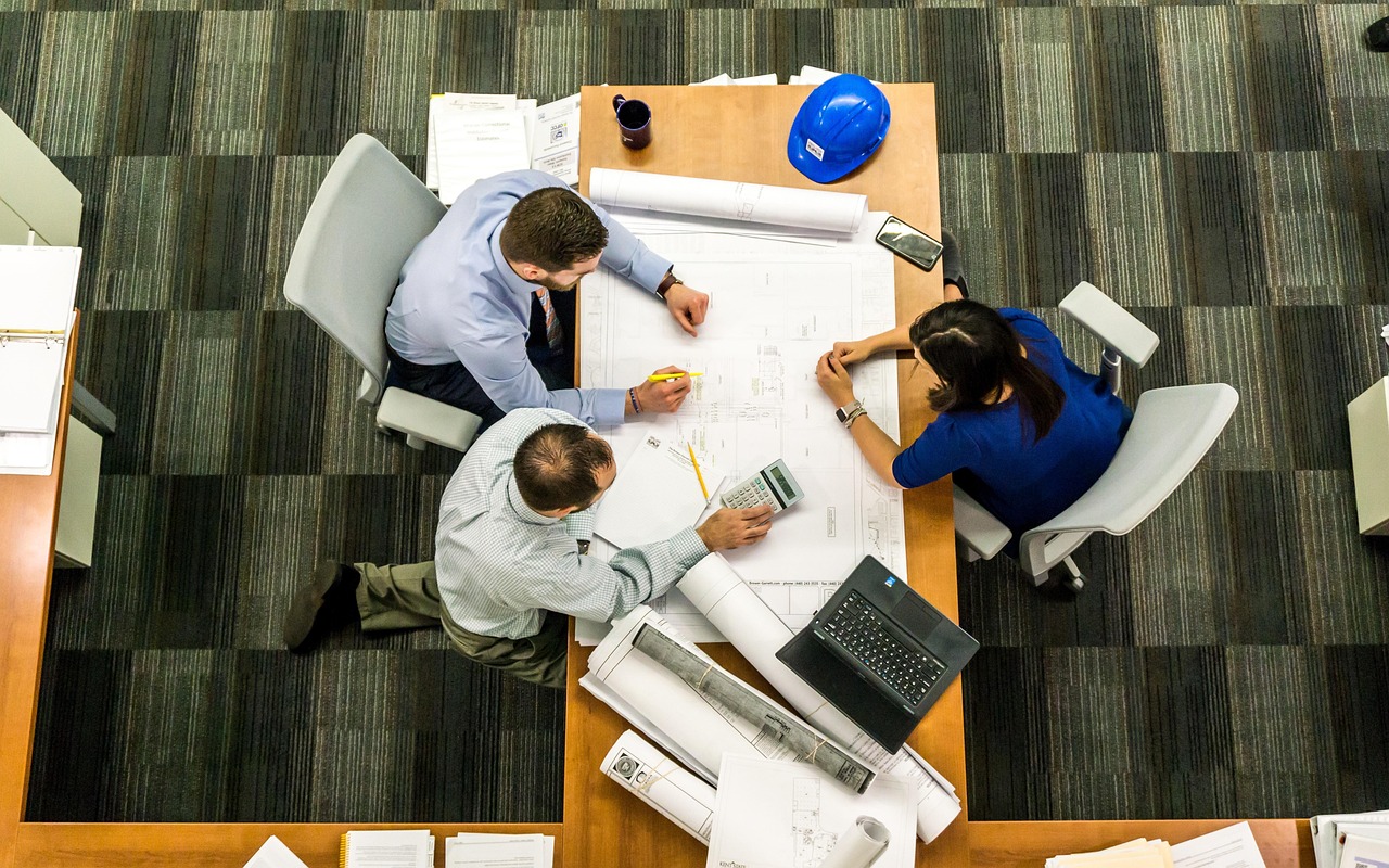 Two teams collaborating at separate office desks