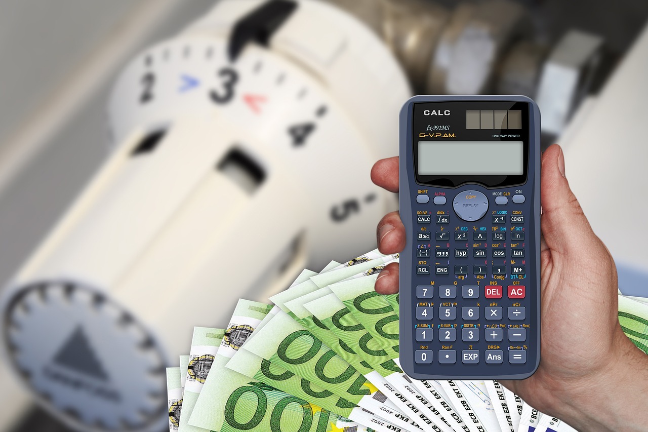 Stacks of coins next to a calculator representing cost