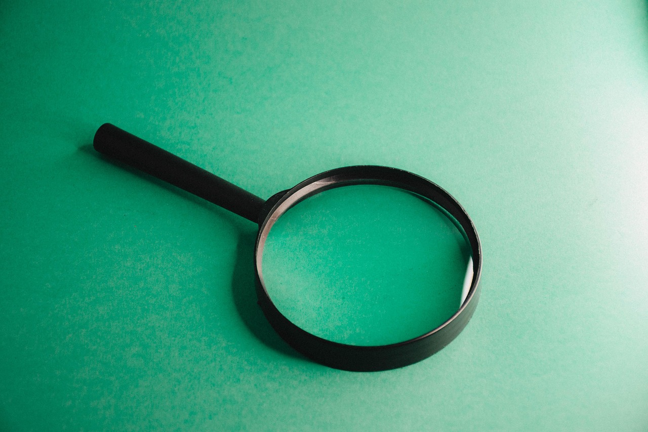 A magnifying glass over a laptop representing exploratory testing